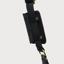 Load image into Gallery viewer, Black strap with gold hardware on a light gray background